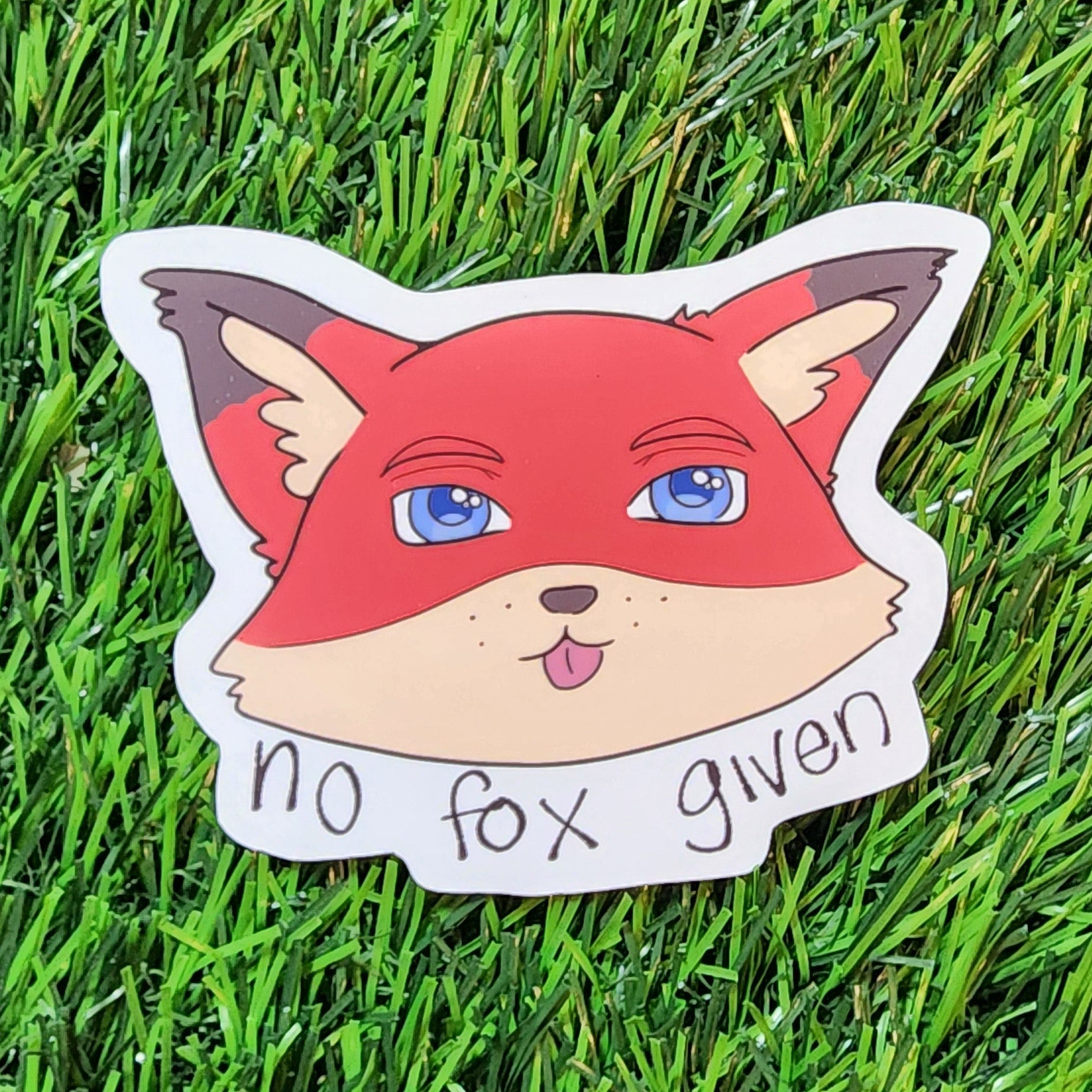 Sticker of a fox face with text 'no fox given' on grass